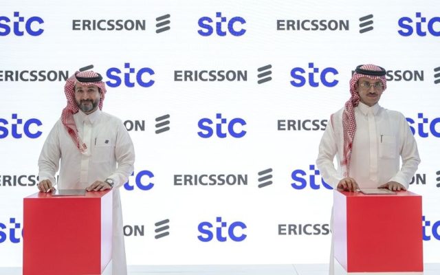 Two men in traditional Saudi dress at a lectern in front of an stc and Ericsson branded backdrop