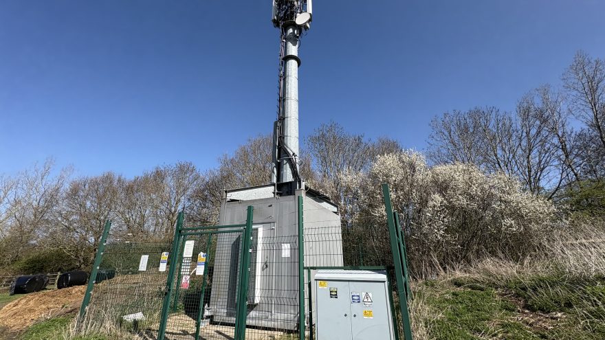 Cellular base station tower with antennas against a clear sky
