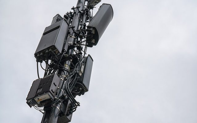 A cluster of cellular 5G antennas mounted near the top of a cell tower