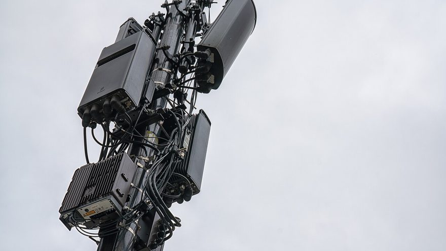 A cluster of cellular 5G antennas mounted near the top of a cell tower