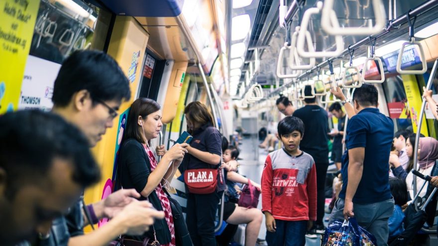 Passengers using smartphones aboard a Singapore metro train