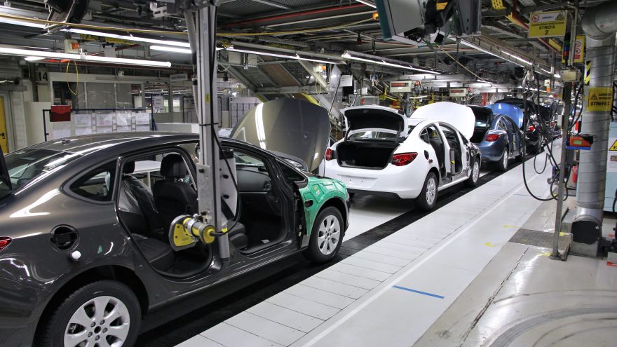 Partially assembled cars on a conveyor line inside an automobile assembly plant